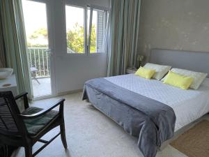 a bedroom with a bed with yellow pillows and a chair at Chalet Las Brisas in Cullera