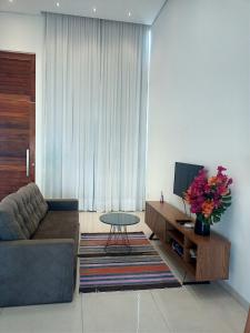 a living room with a couch and a table and a tv at Casa Bela in Bonito