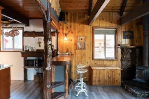 a kitchen with wooden walls and a table and a chair at Knotty Bear Haus in Big Bear City