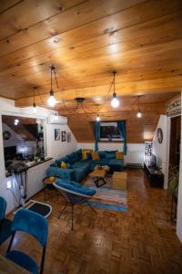 una sala de estar con sofá azul y techos de madera. en Vila Jezerski raj en Bor