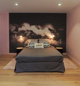 Céshap - Chambres d'hôtes في Taden: غرفة نوم بسرير مع لوحة بالورود