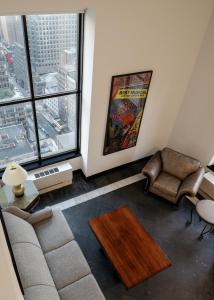sala de estar con sofá y ventana grande en The Manhattan Club, en Nueva York