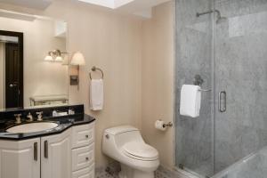 een badkamer met een toilet en een glazen douche bij The Manhattan Club in New York