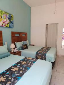 Cette chambre comprend 2 lits et une table. dans l'établissement Casa las Flores, à Puerto Vallarta