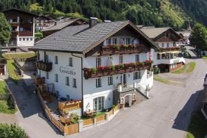 a large white building with flowers on the balconies at Apartments Gannerhof in Obertilliach