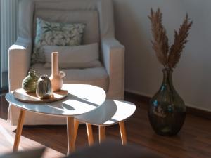 a living room with a chair and a table with vases at Marousi Cozy Apartment in Athens