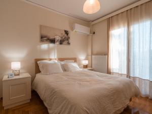 a bedroom with a white bed and a window at Marousi Cozy Apartments in Athens