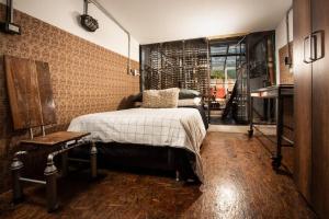 a bedroom with a bed and a brick wall at La Cangreja Casa Biosferista in Bogotá