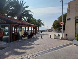 a street with a building and palm trees on a street at Lina in Gradac