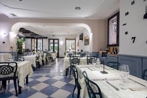 ein Restaurant mit Tischen und Stühlen mit weißen Tischdecken in der Unterkunft Hotel Novara in Verbania