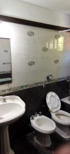 a bathroom with a sink and a toilet and a mirror at "Cerquita del Mar" Casa para 9 personas zona centro Villa Gesell in Villa Gesell