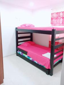 łóżko piętrowe w pokoju z różową pościelą w obiekcie Alojamiento turístico Paula Viktoria w mieście Villavicencio