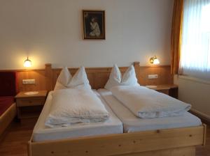 1 Schlafzimmer mit 2 Betten und weißen Kissen in der Unterkunft Klammer Gabi in Obertilliach