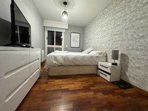 - une chambre avec un lit et un mur en briques dans l'établissement Oktheway Fonteculler, à Culleredo