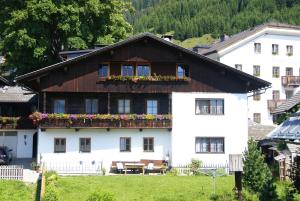Casa blanca con balcón con flores. en Klammer Gabi, en Obertilliach