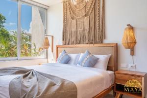 トゥルムにあるNHOA 307B Lux 1BR Condo Pool View in Aldea Zamaの大きなベッドと窓のある寝室 +25枚の写真