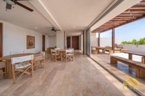 トゥルムにあるNHOA 307B Lux 1BR Condo Pool View in Aldea Zamaのテーブルと椅子と海のあるダイニングルーム