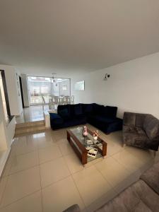 Sala de estar con sofá azul y mesa de centro en Casa Chimenea a 5 minutos del Aeropuerto, en Bogotá