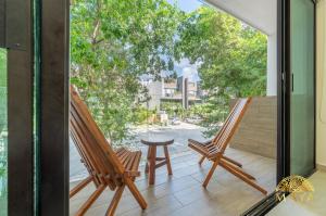 two chairs on a balcony with a view of a street at Selvaterra 201 Lux 2BR Large Condo in Aldea Zama in Tulum