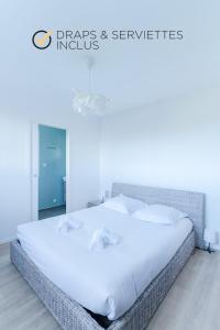 a bedroom with a large bed with white sheets and pillows at TY NEVEZ - Jolie maison neuve avec petite vue mer in Saint-Pabu