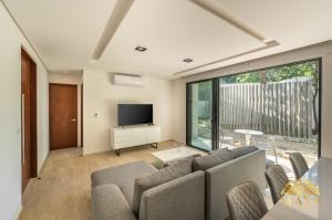 トゥルムにあるPanoramic 108C Lux 1BR Large Condo in La Veletaのソファとテレビのあるリビングルーム