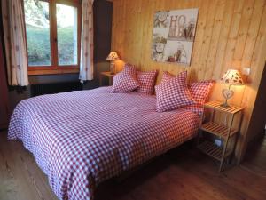 a bedroom with a bed with a red and white checkered blanket at La Demeure des Elfes in Albinen