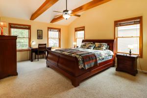 a bedroom with a bed and a desk and windows at Lakefront Poconos Family Home with Pool Access in Pocono Lake +37 photos