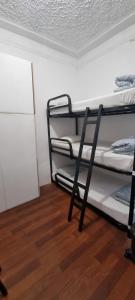 a room with three bunk beds and a wooden floor at Samps Hostel in Lisbon
