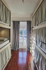 uma sala de estar com uma janela e um piso de madeira em Samps Hostel em Lisboa