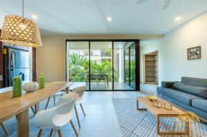 a living room with a blue couch and a table at Selvaterra 201 Lux 2BR Large Condo in Aldea Zama in Tulum
