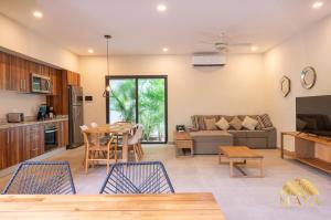 トゥルムにあるSelvaterra 102 Lux 2BR Large Condo in Aldea Zamaのテーブルと椅子のあるキッチンとリビングルーム