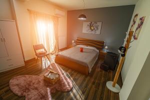 ein Schlafzimmer mit einem Bett und einem Stuhl in der Unterkunft Eclectic 2BR apartment in Volos
