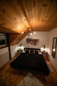 1 dormitorio con cama grande y techo de madera en Vila Jezerski raj en Bor