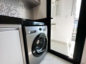 una lavadora y secadora en una cocina con ventana en Bombinhas Monserrate, en Bombinhas
