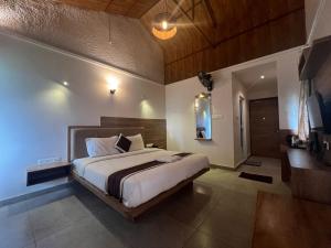 ein Schlafzimmer mit einem großen Bett in einem Zimmer in der Unterkunft Chill Berg Resort - Bodimettu in Theni Allinagaram