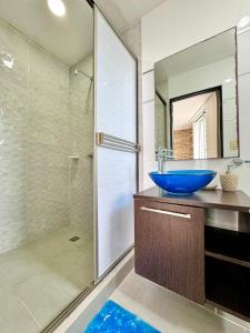 a bathroom with a blue bowl sink and a shower at HELENE HOUSE in Sincelejo