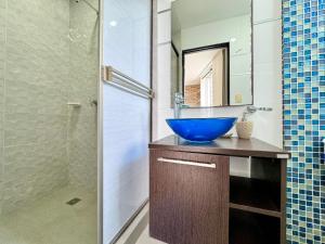 ein Badezimmer mit einem blauen Waschbecken und einer Dusche in der Unterkunft HELENE HOUSE in Sincelejo