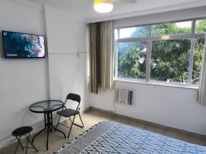 Habitación con 2 sillas, mesa y ventana en Leblon apartment - Two bedroom,, en Río de Janeiro
