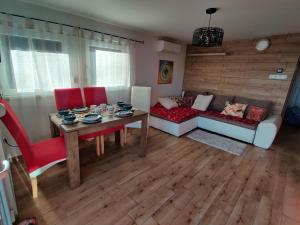 een woonkamer met een tafel en rode stoelen bij Krisztina Vendégház Leányfalu - Különálló - itt csak Ti vagytok in Leányfalu