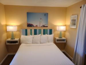 a bedroom with a large bed with two lamps at Sunny Cove Motel in Santa Cruz