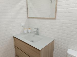 een witte badkamer met een wastafel en een spiegel bij El Yate Sol y Mar in Aguadulce