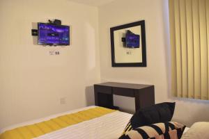 1 dormitorio con cama, escritorio y espejo en Alojamiento cómodo: Casa ideal en Morelia