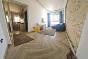 sala de estar con suelo de madera y sofá en شقة فاخرة مكيفة تري البحر مباشرة, en Alejandría
