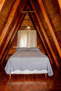 uma cama no sótão de um chalé de madeira em Chalé Sunset em Piçarras