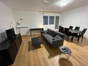 ein Wohnzimmer mit einem Sofa und einem Tisch in der Unterkunft 4 pièces à Créteil avec parking près du centre/lac in Créteil