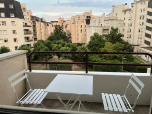 einen weißen Tisch und zwei Stühle auf dem Balkon in der Unterkunft 4 pièces à Créteil avec parking près du centre/lac in Créteil