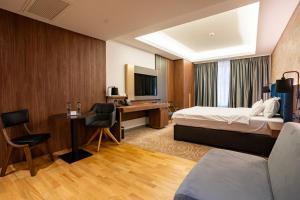 a hotel room with a bed and a desk at ATLAS Hotel in Timişoara