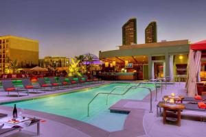 einen Pool in einem Hotel mit Stühlen und Tischen in der Unterkunft Bay Views & Gaslamp/Little Italy/Convention 1BD in San Diego