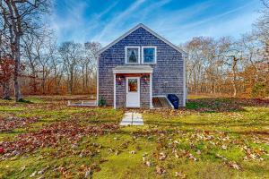 a small blue house in the middle of a field at Vineyard Vacation Cottage in Chilmark