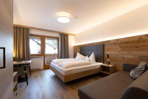 a hotel room with a bed and a desk at Hotel Thuinerwaldele in Vipiteno